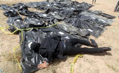 Iraqi man cries over body-bags containing the remains of people believed to have been slain by jihadists in TIkrit