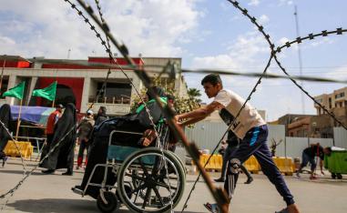 طفل عراقي يدفع عجوزا لزيارة ضريح الامام الكاظم في بغداد