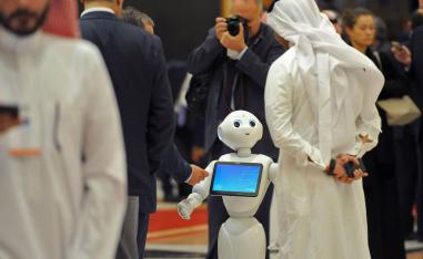 سعودي ينظر إلى روبوت في مؤتمر بالرياض