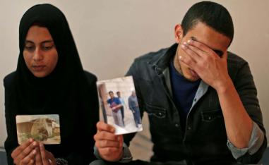 The daughter (L) and son of Zaki Mubarak hold his picture