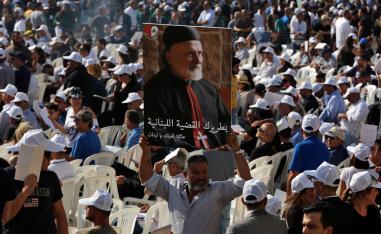 A mourner holds up a picture of former Maronite Patriarch Cardinal Mar Nasrallah Boutros Sfeir