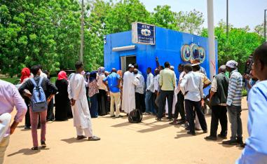 Sudanese people queue up to withdraw money from an ATM in Sudan's capital Khartoum.