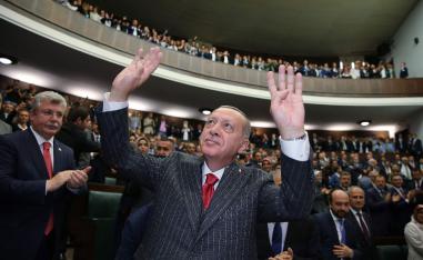 Turkish President Recep Tayyip Erdogan (C) gesturing in front of members of ruling Justice and Development Party (AKP)
