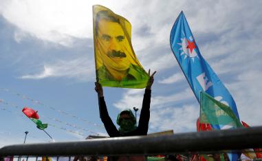 A man holds a flag with a picture of imprisoned Kurdish rebel leader Abdullah Ocalan