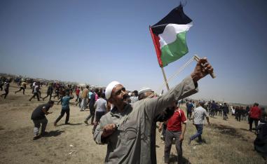 فلسطيني يرمي بحجارة على الحدود بين غزة وإسرائيل