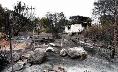 A house and its surroundings damaged by wildfires are seen at kibbutz Harel during a record heatwave in Israel
