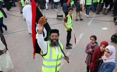 A Libyan protester holds a croissant as he attends a demonstration in Tripoli