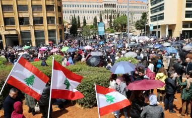 Public sector workers hold Lebanese flags during a protest in downtown Beirut
