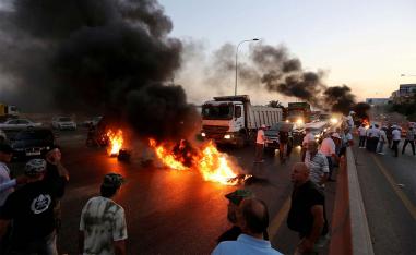Army veterans burn tires during a protest over a state budget that includes a provision taxing their pensions