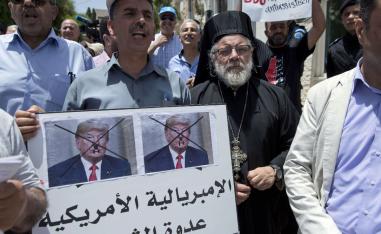 Palestinians protest in Ramallah with sign that reads, 'American imperialism is the people's enemy'.