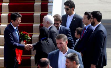 Japan's Prime Minister Shinzo Abe (L) is greeted by Iran's Foreign Minister Mohammad Javad Zarif at Tehran's Mehrabad airport