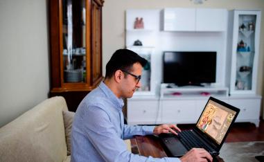 Turkish artist Ugur Gallenkus works with his laptop at his home on April 14, 2019 in Istanbul