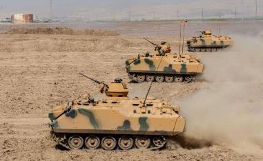 Turkish soldier ride armoured vehicles near the Habur crossing gate between Turkey and Iraq