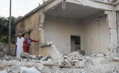 Syrians inspect the damage following reported regime airstrikes on the town of Muhambal