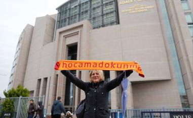 A demonstrator holds scarf reading "Do not touch my Academics"