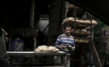 A vendor counts his money at a bread stand in the Sayeda Zeinab neighborhood of Cairo