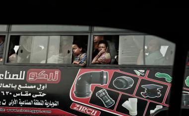 Commuters ride a public bus as they wait in traffic, in Cairo