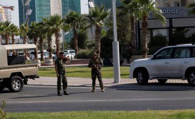 Kurdish security members stand guard near a restaurant where Turkish diplomats and Turkish consulate employee were killed in Erbil