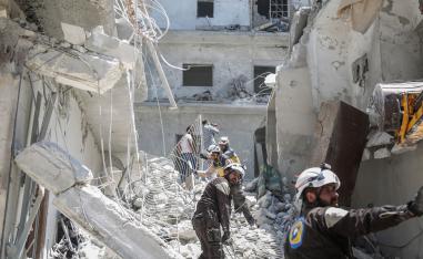 Members of the Syrian Civil Defence search for victims or survivors after an air strike