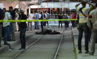 Onlookers gather at the scene outside a metro station where a man blew himself up