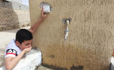 A boy drinks water during a water shortage in Tripoli, Libya