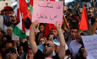 A Palestinian protester shouts slogans as he holds up an Arabic placard that reads: "Don't be silent when it comes to your rights"