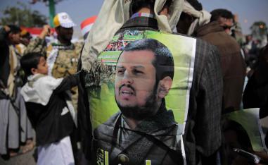 A Huthi supporter displays a poster of Abdel-Malek al-Houthi