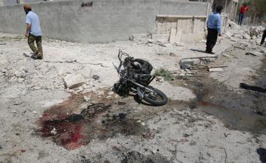 Blood seen next to a damaged motorcycle after an explosion hits a residential neighbourhood in Idlib