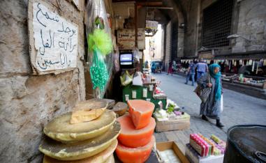 Egyptians walk in front of shops selling candles at Bab El Khalq street at al-Ghouria in old Islamic Cairo