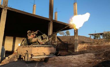 A fighter from the former al-Qaeda Syrian affiliate Hayat Tahrir al-Sham (HTS) fires an anti-aircraft gun mounted on a pickup truck in Syria's southern Idlib province 