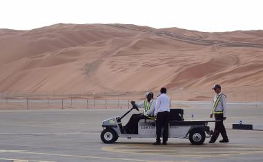 Aramco staff members stand on the tarmac at the Saudi Aramco airport