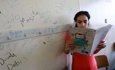 طفلة فلسطينية تقرأ قصة في مخيم بلبنان