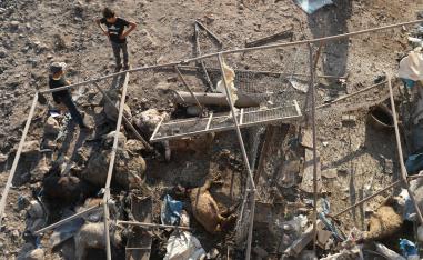 Syrian boys look at a destroyed sheep pen following a reported Russian air strike in Idlib province