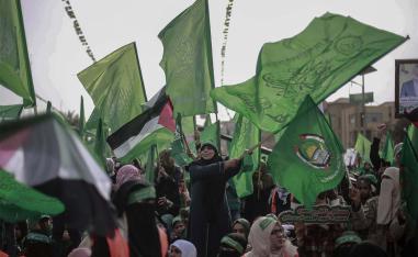 Palestinian women wave green Hamas flags during a rally marking the 31st anniversary of the founding of the Islamist movement Hamas last year