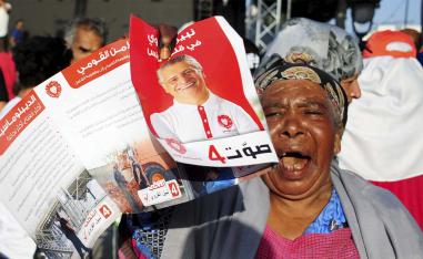 A supporter of jailed Tunisian presidential candidate Nabil Karoui shows his portrait during a gathering in Tunis
