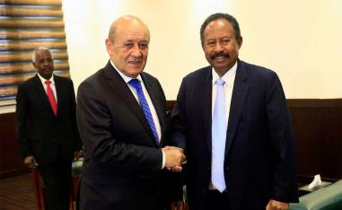 Sudan's PM Abdalla Hamdok shakes hands with French FM Jean-Yves Le Drian during their meeting in Khartoum