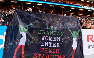 Iranian football supporters hold a banner reading 'let Iranian women enter their stadiums' 