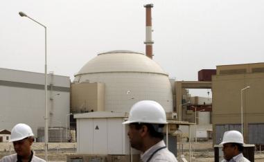 Iranian technicians walk outside the building housing the reactor of Bushehr nuclear power plant