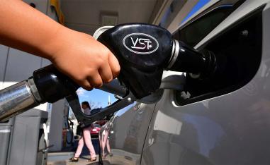 A child pumps gas for his father at a gas station in Los Angeles