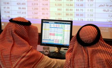 A Saudi man looks at the computer showing stock prices at ANB Bank in Riyadh