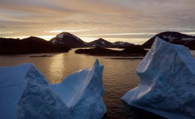An aerial view of large Icebergs floating as the sun rises near Kulusuk, Greenland