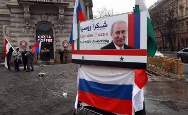 Syrians in Hungary demonstrate next to a poster depicting Russian President Valdimir Putin and reading "Thanks Russia" in downtown Budapest