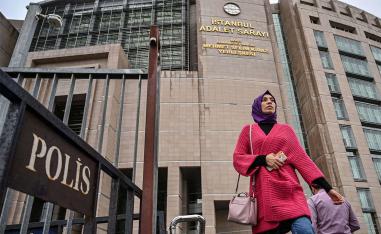 People walk outside of Istanbul's courthouse during the trial of dozens of defendants