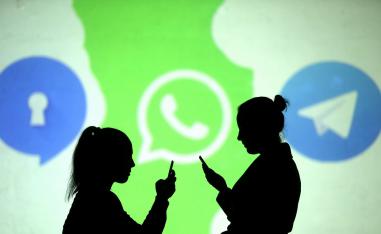 ظلال لمستخدمي هواتف محمولة تظهر بجوار شعارات واتساب وتليغرام وسيغنال