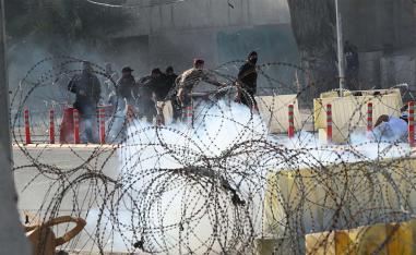 Iraqi security forces fire tear gas to disperse anti-government protesters during a demonstration in central Baghdad,