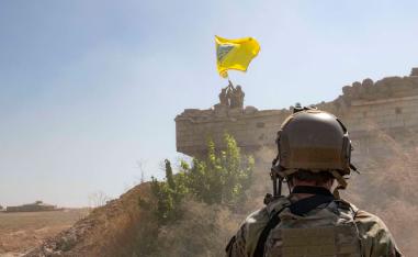 US Soldier oversees members of the Syrian Democratic Forces as they demolish a Kurdish fighters' fortification near Syria's border with Turkey