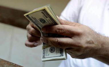 A teller counts US dollars at a currency exchange company in the Lebanese capital Beirut 