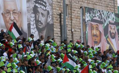 فلسطينيون يحضرون مباراة بين الفريق السعودي والفريق الفلسطيني في الرم في الضفة الغربية