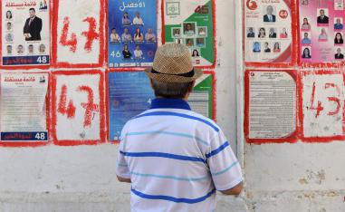 A Tunisian man looks at posters of legislatives' candidates in the capital Tunis