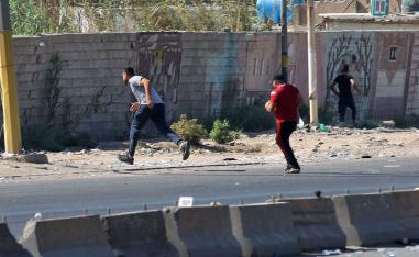 Iraqi protesters run during demonstration against state corruption and failing public services